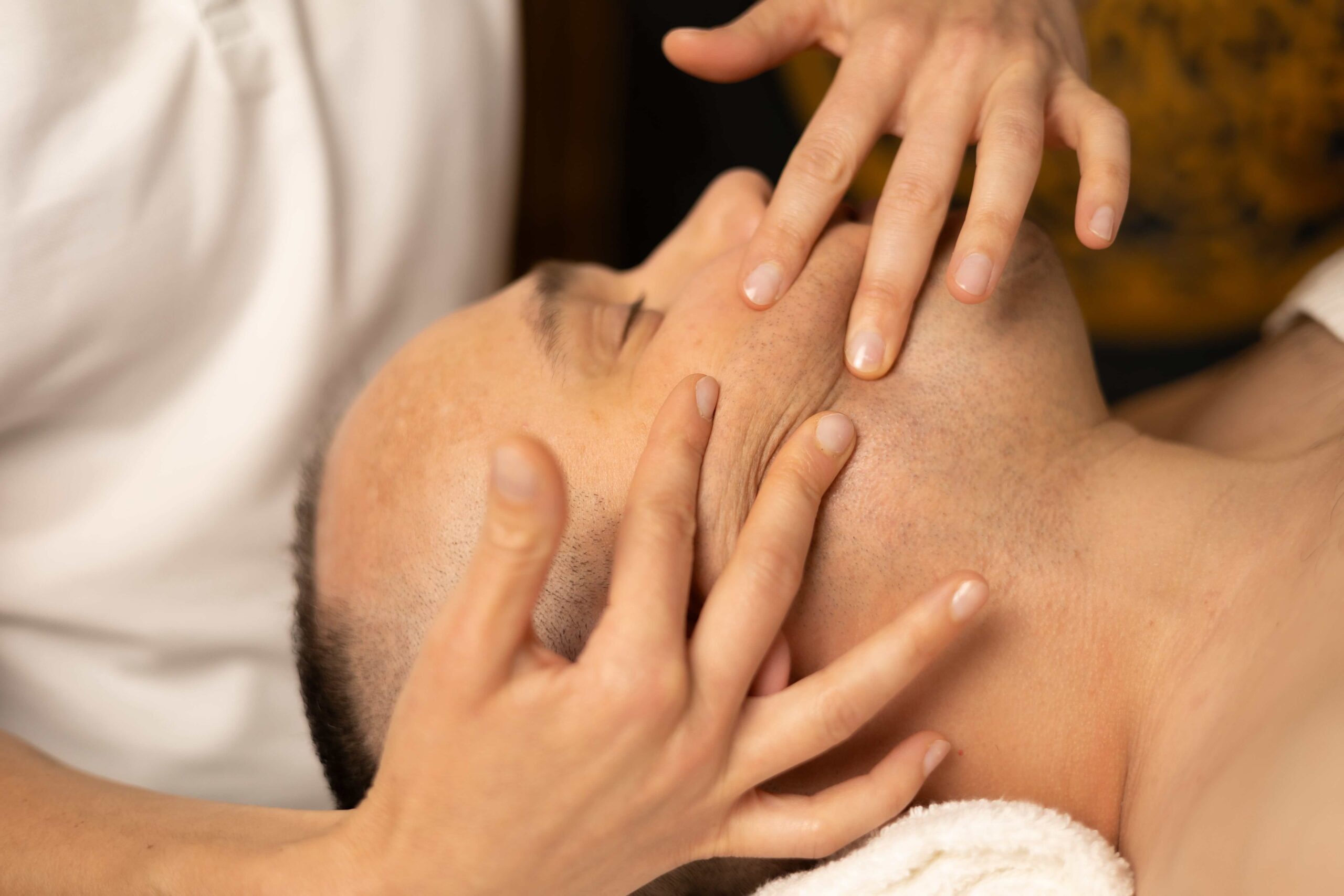 terapeutka wykonująca liftingujący masaż twarzy Kobido u klienta