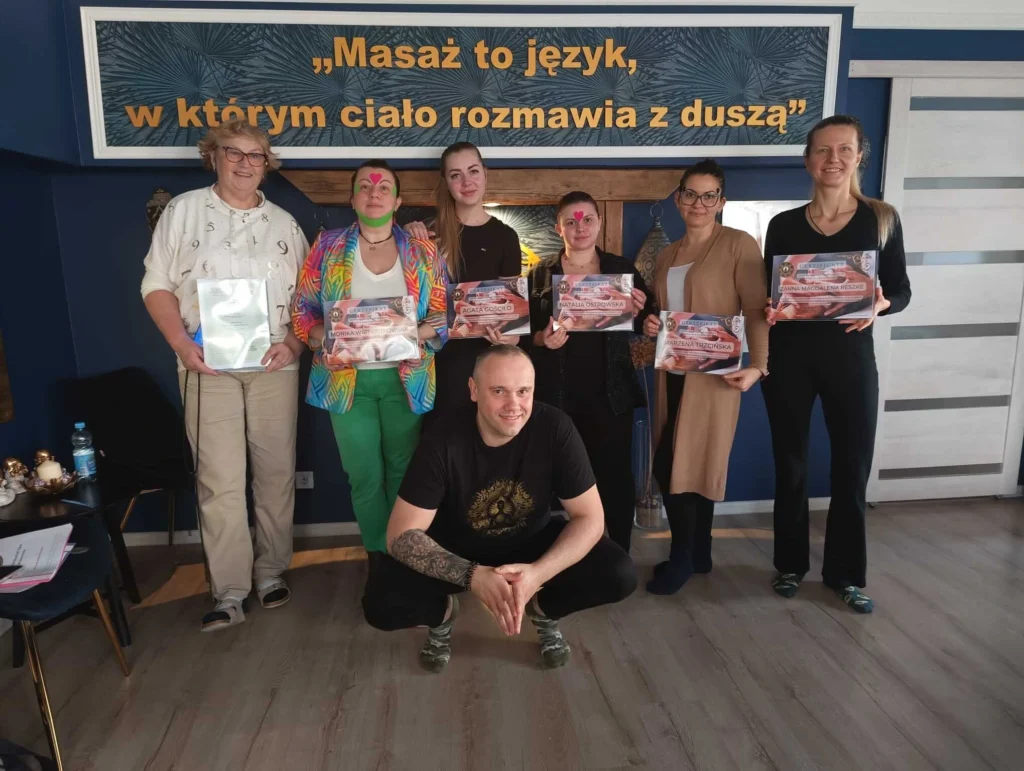 Grupa kursantek z certyfikatami po ukończeniu szkolenia masażu w Akademii Oriental SPA, wraz z instruktorem Tomaszem Wiśniewskim